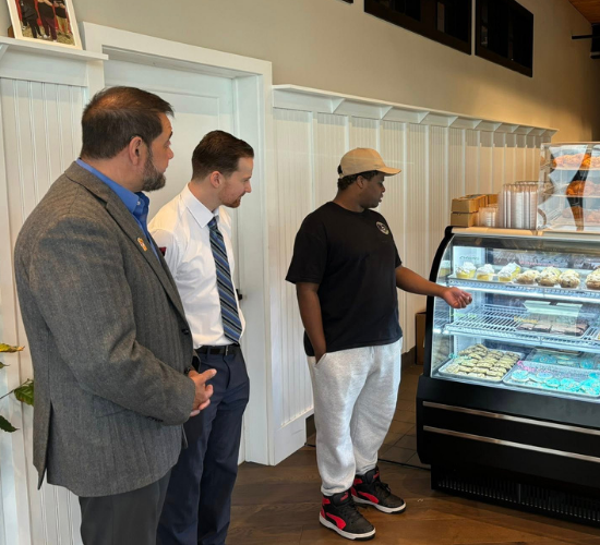 Coffee Inclusive team member giving Carl Sheperis and Anthony Melf a tour of the coffee shop