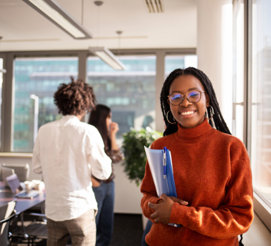 Woman holding folder and smiling in an office