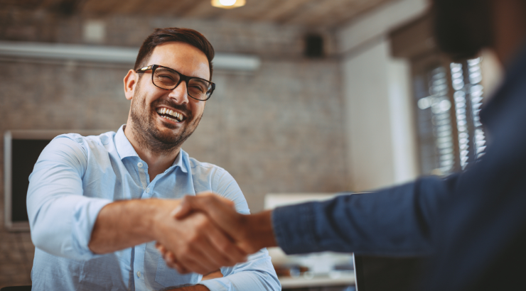 Man smiling and shaking a hand